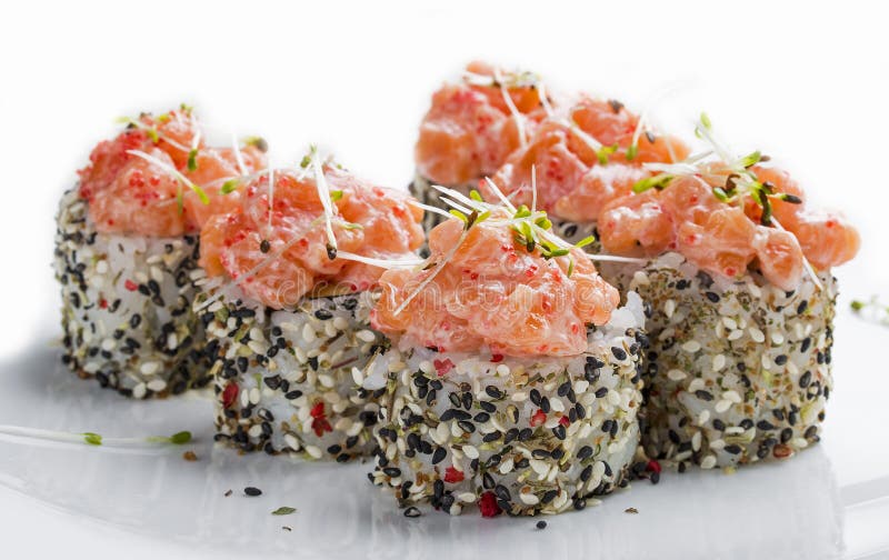 Sushi roll in sesame with smoked salmon and alfalfa