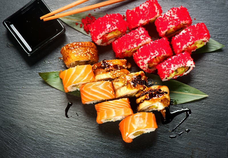 Sushi rolls closeup. Japanese food in restaurant. Roll with salmon, eel, vegetables and flying fish caviar