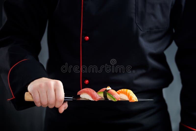 Sushi served on japanese knife in chef hand