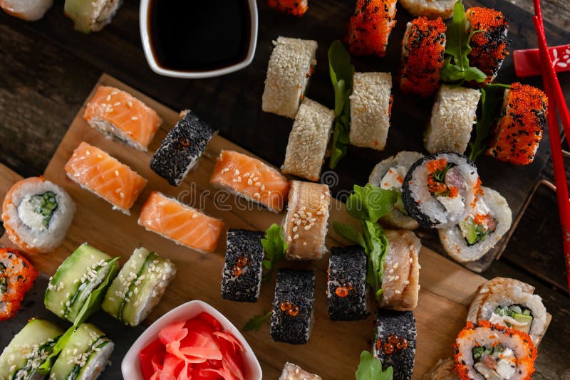 Sushi set food photo. Rolls served on brown wooden and slate plate. Close up and top view of sushi royalty free stock photography Sushi set food photo. Rolls served on brown wooden and slate plate. Close up and top view of sushi royalty free stock photography