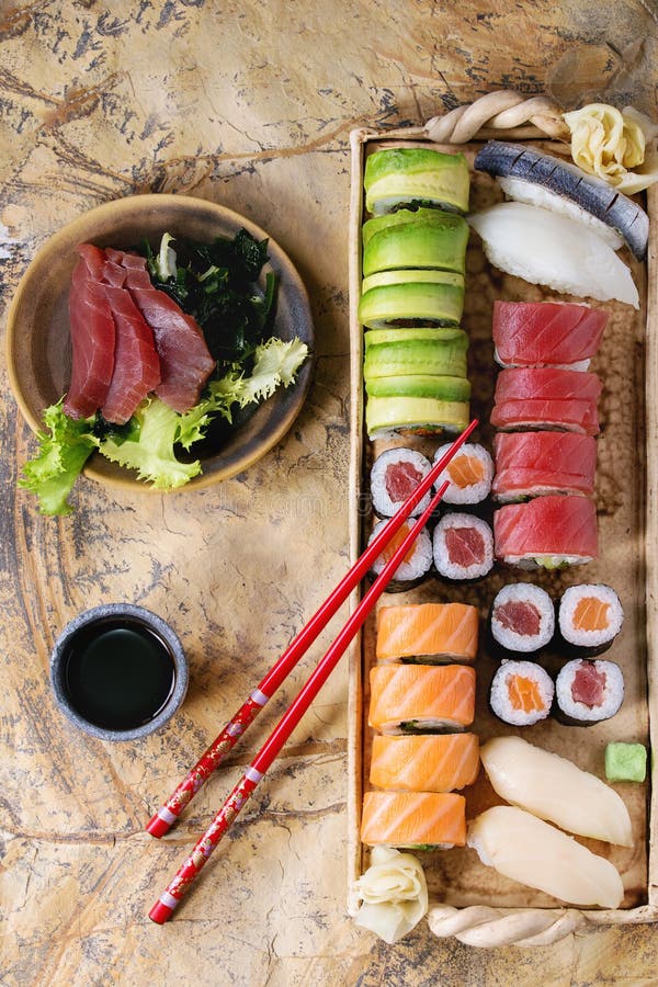 Sushi Set nigiri sashimi and sushi rolls on wooden serving board with soy  sauce and chopsticks over grey concrete background. Flat lay, space. Japan  menu Stock Photo