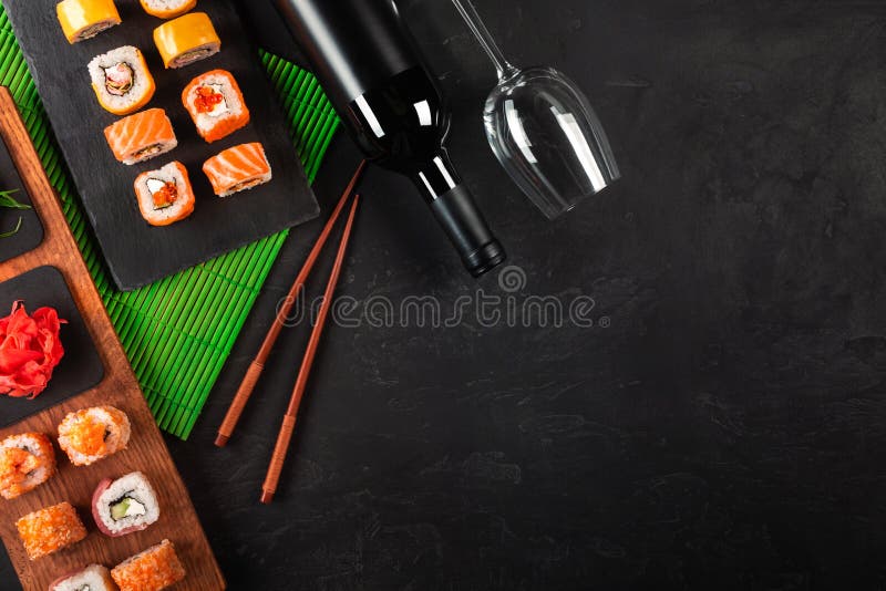 Sushi Set sashimi and sushi rolls, bottle of wine and a glass served on stone slate royalty free stock photography Sushi Set sashimi and sushi rolls, bottle of wine and a glass served on stone slate royalty free stock photography