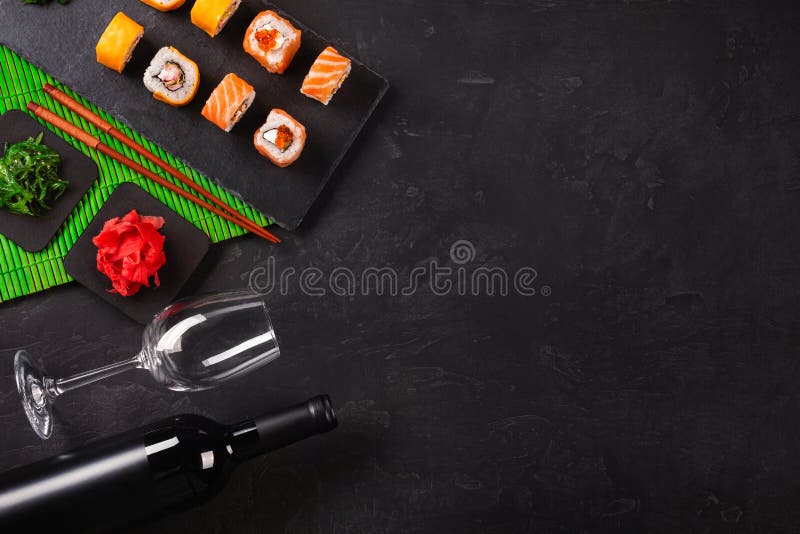 Sushi Set sashimi and sushi rolls, bottle of wine and a glass served on stone slate stock photography Sushi Set sashimi and sushi rolls, bottle of wine and a glass served on stone slate stock photography