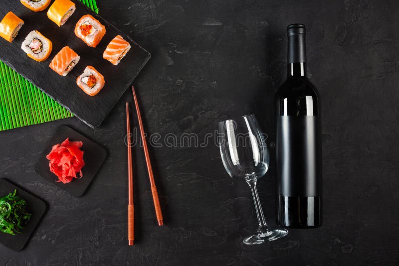 Sushi Set sashimi and sushi rolls, bottle of wine and a glass served on stone slate royalty free stock photo Sushi Set sashimi and sushi rolls, bottle of wine and a glass served on stone slate royalty free stock photo