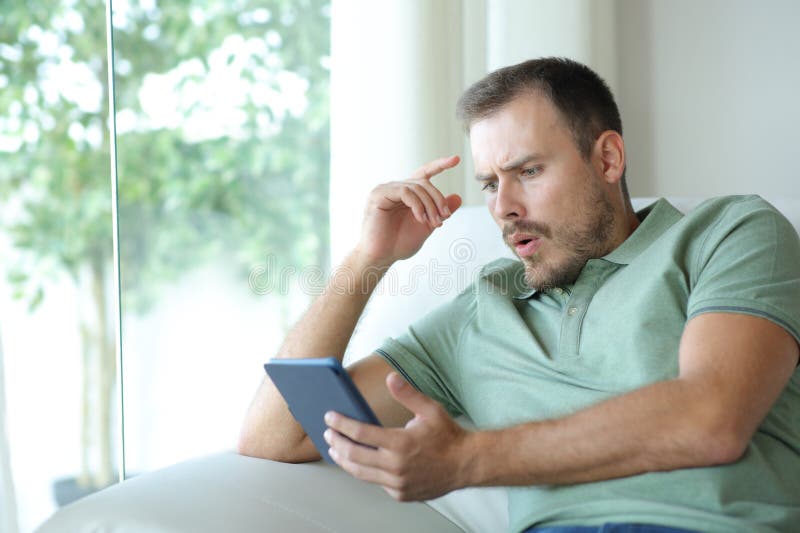 Susprised man reading a ebook after plot twist stock photos