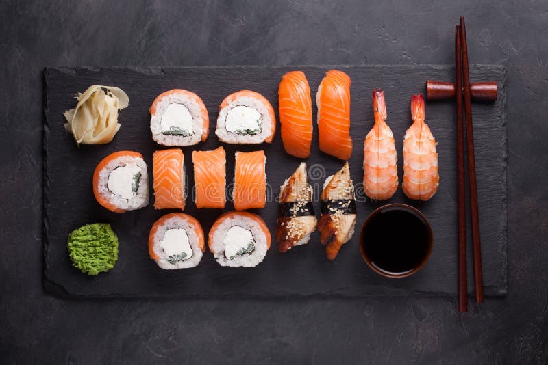 Suszi Ustalony sashimi z łososia, garneli, węgorza i suszi rolkami Philadelphia, słuzyć na kamienia łupku Odgórny widok fotografia stock Suszi Ustalony sashimi z łososia, garneli, węgorza i suszi rolkami Philadelphia, słuzyć na kamienia łupku Odgórny widok fotografia stock