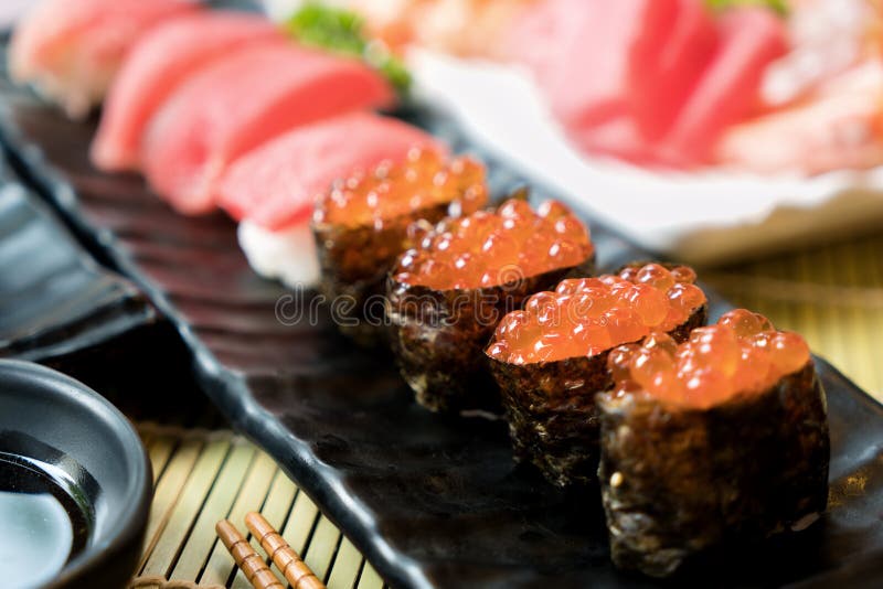 Suszi z chopsticks i soja kumberlandem Suszi rolki japoński jedzenie w restauraci Łososiowy roe suszi ustawiający z łososiem, war zdjęcia stock Suszi z chopsticks i soja kumberlandem Suszi rolki japoński jedzenie w restauraci Łososiowy roe suszi ustawiający z łososiem, war zdjęcia stock