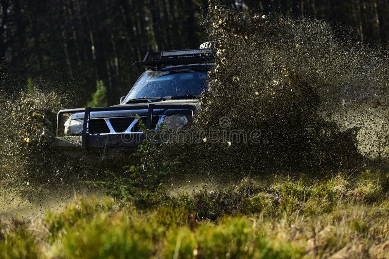 SUV oder Auto nicht für den Straßenverkehr auf dem Weg bedeckt mit Grasüberfahrtpfütze mit Schmutzspritzen Extrem, Herausforderun lizenzfreie stockfotografie SUV oder Auto nicht für den Straßenverkehr auf dem Weg bedeckt mit Grasüberfahrtpfütze mit Schmutzspritzen Extrem, Herausforderun lizenzfreie stockfotografie