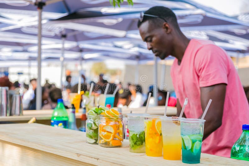 Soweto, South Africa - September 17, 2017: Diverse African vendor serving cocktail drinks at outdoor festival. Soweto, South Africa - September 17, 2017: Diverse African vendor serving cocktail drinks at outdoor festival