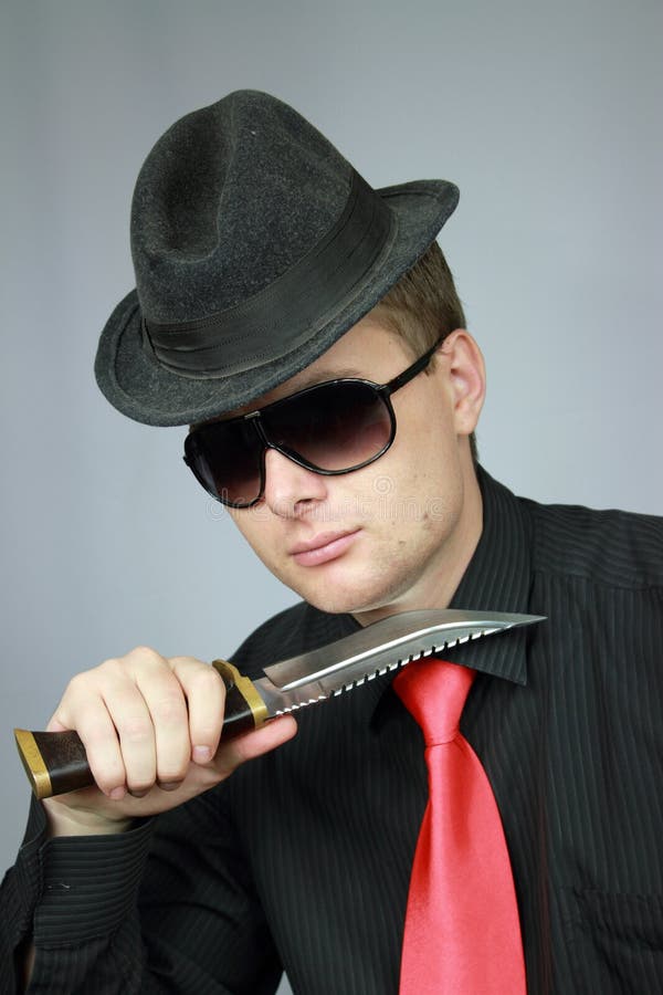 Businessman in a black shirt with a knife in hands. Businessman in a black shirt with a knife in hands