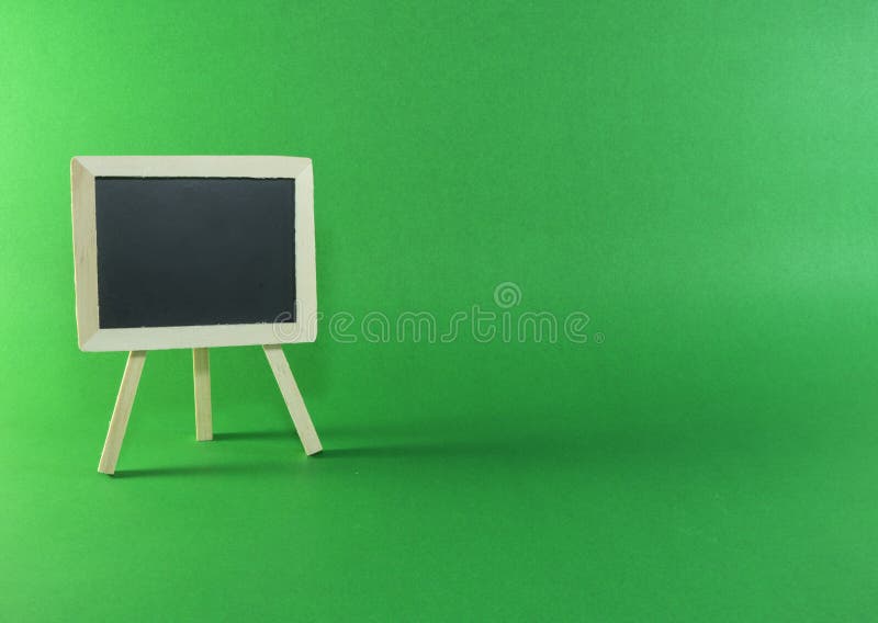 Svart bräde med kopieringsutrymme på grön bakgrund arkivbilder Svart bräde med kopieringsutrymme på grön bakgrund arkivbilder