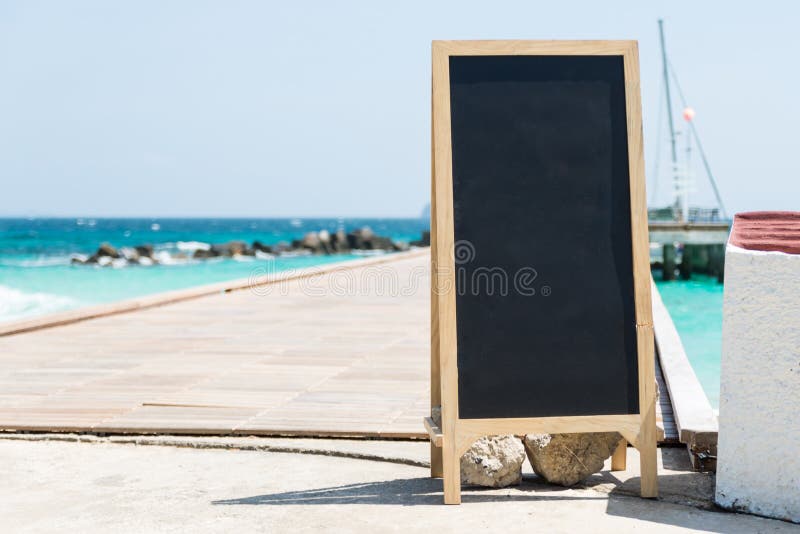 Svart bräde på port med det klara blåa havet, vit sand och blå himmel på ön arkivbilder Svart bräde på port med det klara blåa havet, vit sand och blå himmel på ön arkivbilder