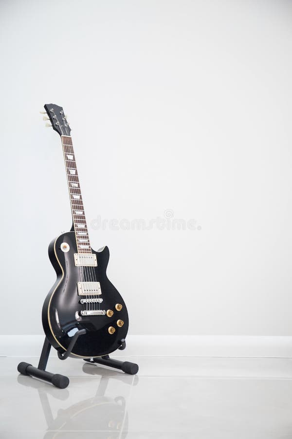 Svart elektrisk gitarr. Närbild av den svarta elektriska gitarren på vit bakgrund
