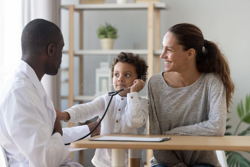 Svart läkare som visar hur fonendoskop fungerar för en liten söt patient royaltyfri bild