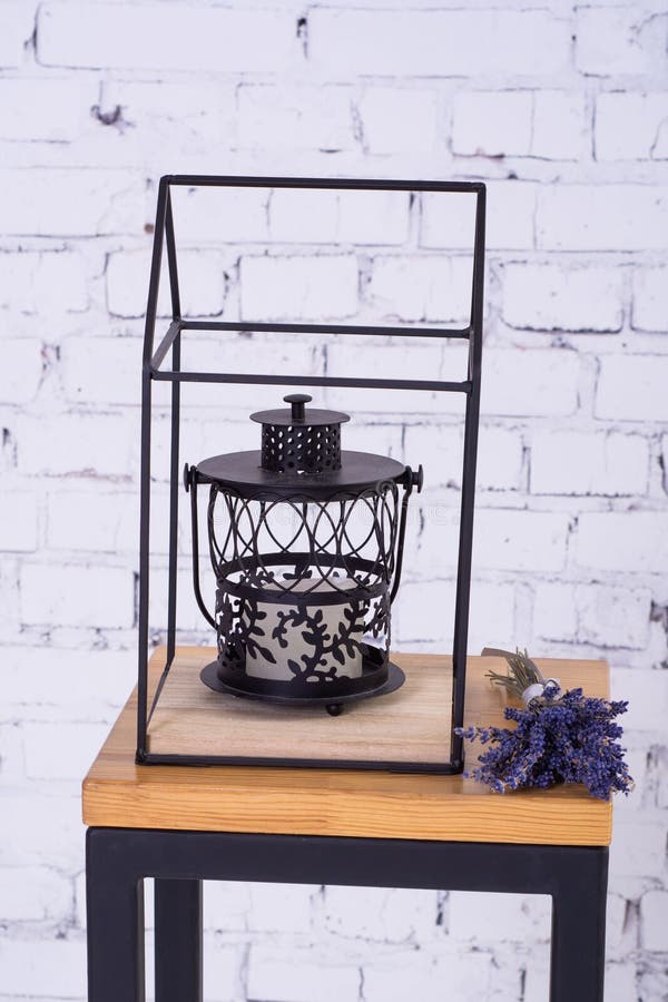 Svart metalllampa och en bukett av lavendel på en liten trätabell arkivfoton Svart metalllampa och en bukett av lavendel på en liten trätabell arkivfoton