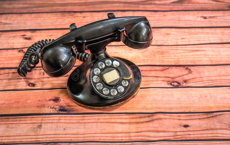 Svart roterande telefon för Retro tappning på skeva träSlats royaltyfri fotografi Svart roterande telefon för Retro tappning på skeva träSlats royaltyfri fotografi