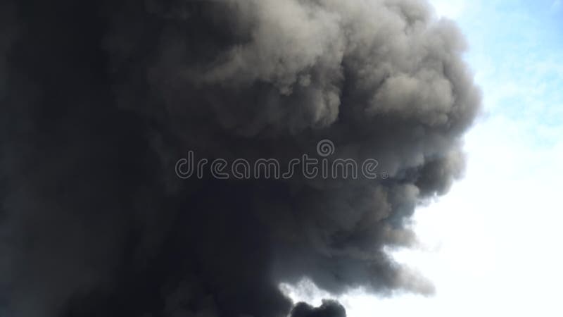Black smoke rises into the sky. A big chemical fire at a factory building. Thick black smoke covers the sky. 4k. Black smoke rises into the sky. A big chemical fire at a factory building. Thick black smoke covers the sky. 4k
