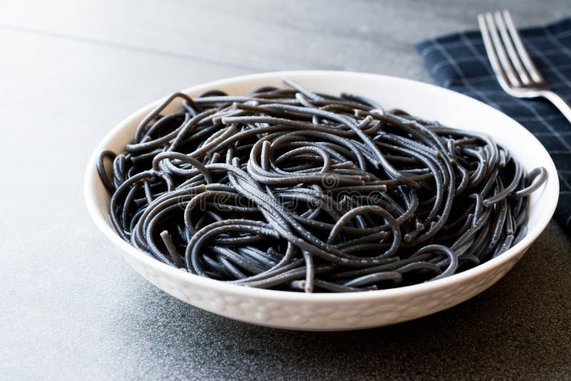 Svart spagettipasta som smaksättas med tioarmad bläckfiskfärgpulverbläckfisken eller Inkfish royaltyfri bild Svart spagettipasta som smaksättas med tioarmad bläckfiskfärgpulverbläckfisken eller Inkfish royaltyfri bild