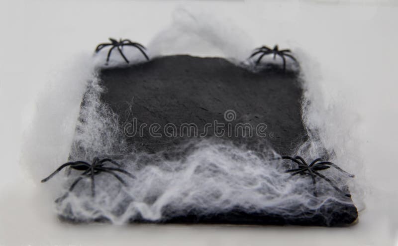 Svart tavlamaträtt som dekoreras med spindlar och spindelrengöringsduken för halloween royaltyfri fotografi Svart tavlamaträtt som dekoreras med spindlar och spindelrengöringsduken för halloween royaltyfri fotografi