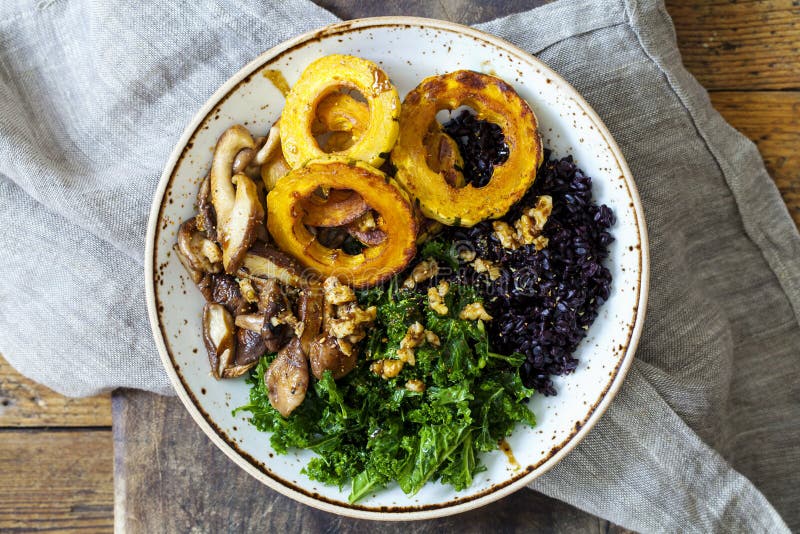 Svarta ris med grillad delicatasquash, masserad grönkål och shiitakechampinjoner arkivfoto Svarta ris med grillad delicatasquash, masserad grönkål och shiitakechampinjoner arkivfoto