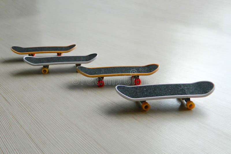 Svarta skateboarder på grå randig yttersida Skridskobrädegrupp av fyra med skuggor och den delvis mjuka fokusen Perspektivsikt av arkivfoton Svarta skateboarder på grå randig yttersida Skridskobrädegrupp av fyra med skuggor och den delvis mjuka fokusen Perspektivsikt av arkivfoton