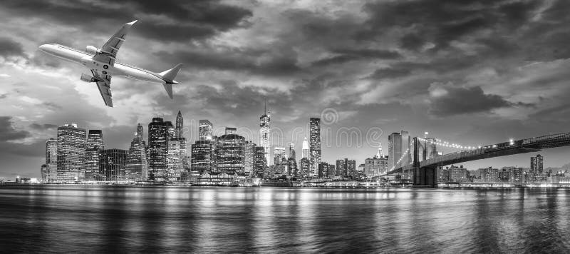 Svartvit sikt av flygplanet som flyger över New York City royaltyfri bild