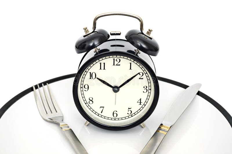 Sveglia con la forcella e coltello sul piatto isolato su fondo bianco Tempo di mangiare Perdita di peso o concetto di dieta immagine stock libera da diritti Sveglia con la forcella e coltello sul piatto isolato su fondo bianco Tempo di mangiare Perdita di peso o concetto di dieta immagine stock libera da diritti