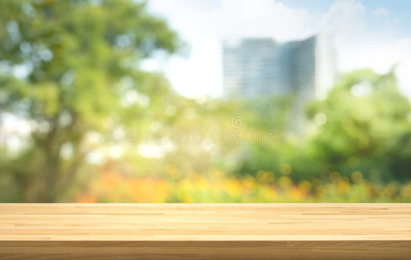 Svuoti del piano d'appoggio di legno su sfuocatura del giardino verde fresco con gli ambiti di provenienza della città della citt