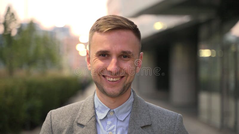 Sväng ung affärsman som tittar på kameran i staden. långsam rörelse royaltyfri foto