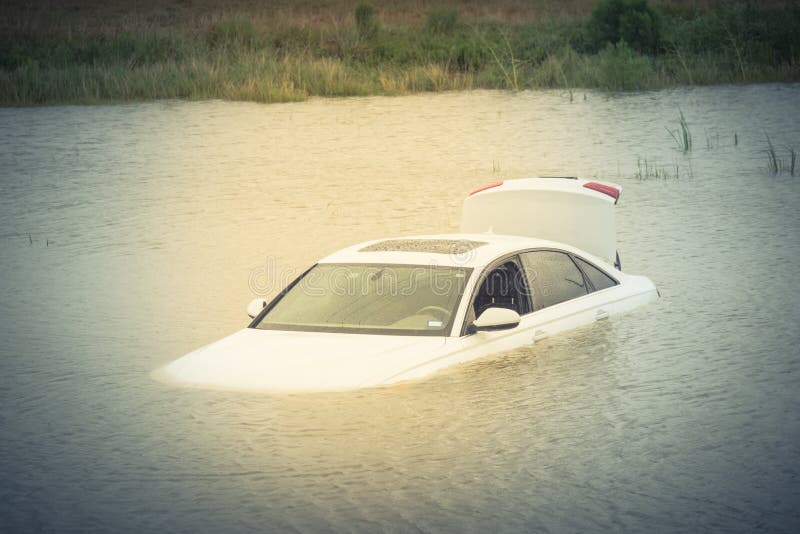 Sedan car swamped by flood water in East Houston, Texas, US by Harvey Tropical Storm. Submerged car on deep heavy high water road. Disaster Motor Vehicle Insurance Claim Theme. Severe weather. Vintage. Sedan car swamped by flood water in East Houston, Texas, US by Harvey Tropical Storm. Submerged car on deep heavy high water road. Disaster Motor Vehicle Insurance Claim Theme. Severe weather. Vintage