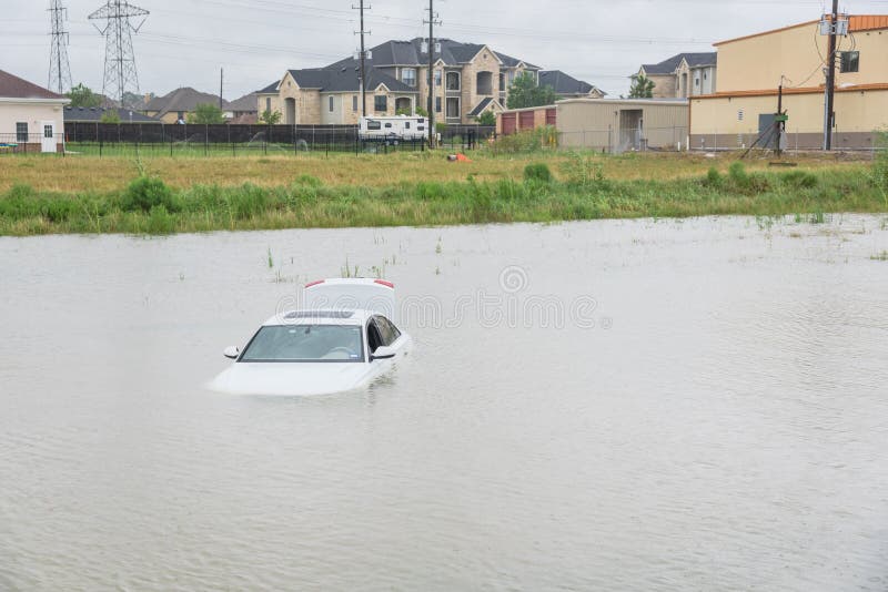 Sedan car swamped by flood water in East Houston, Texas, US by Harvey Tropical Storm. Submerged car on deep heavy high water road. Disaster Motor Vehicle Insurance Claim Themed. Severe weather concept. Sedan car swamped by flood water in East Houston, Texas, US by Harvey Tropical Storm. Submerged car on deep heavy high water road. Disaster Motor Vehicle Insurance Claim Themed. Severe weather concept