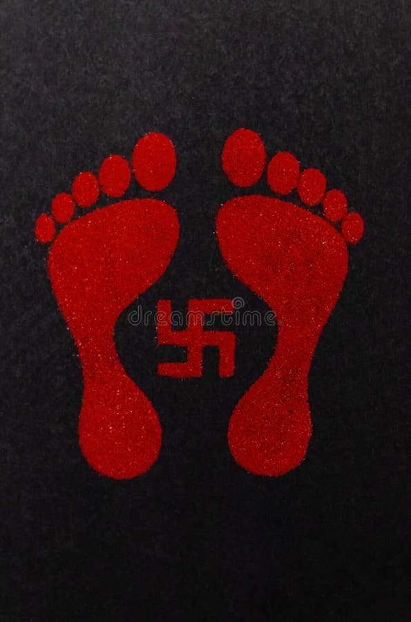 Swastika sign and lakshmi footprints decorated with red kumkum on black background. deepawali and dhanteras concept