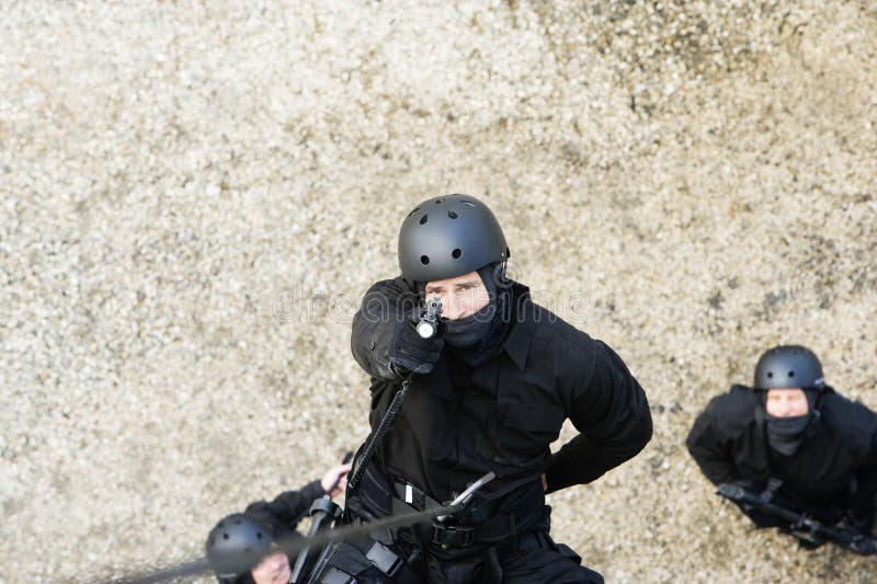 SWAT Team Officer Rappelling and Aiming Gun Stock Image Image of