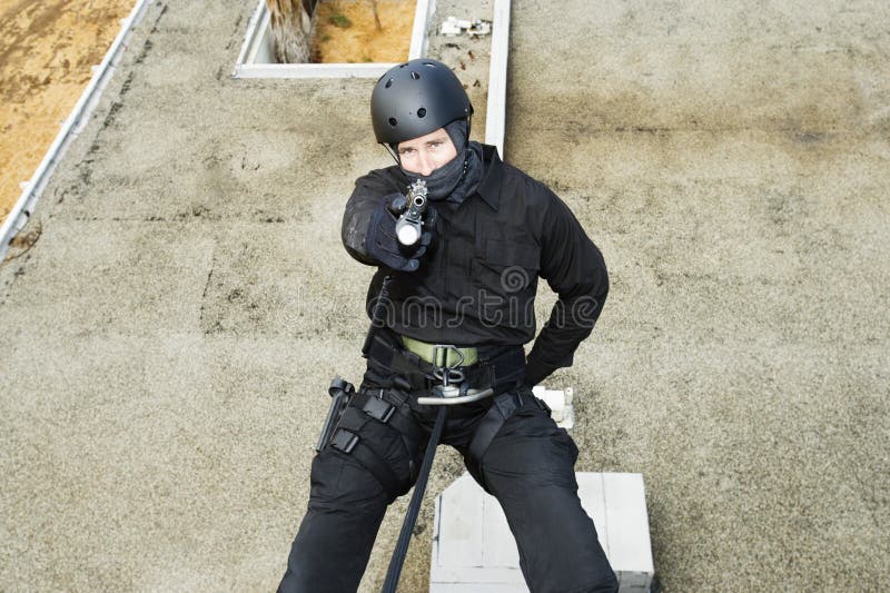 SWAT Team Officer Rappelling and Aiming Gun Stock Image Image of