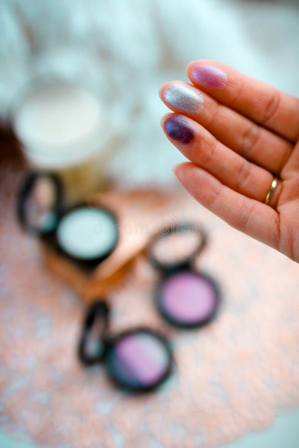 Swatch de sombras de ojos en los fingeres femeninos con el backgroud borroso foto de archivo libre de regalías Swatch de sombras de ojos en los fingeres femeninos con el backgroud borroso foto de archivo libre de regalías