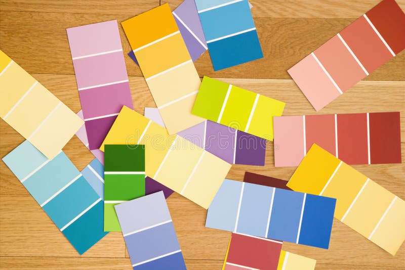 Paint color swatches spread out on wood floor. Paint color swatches spread out on wood floor.