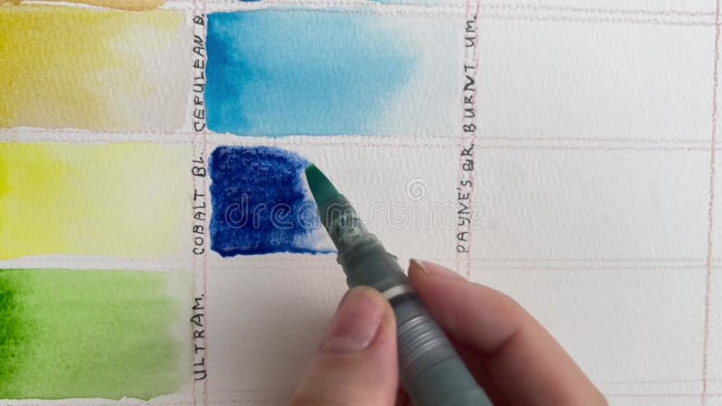 Swatching cobalt blue watercolor paint on textured 100 per cent cotton paper using a waterbrush. Colour chart of a