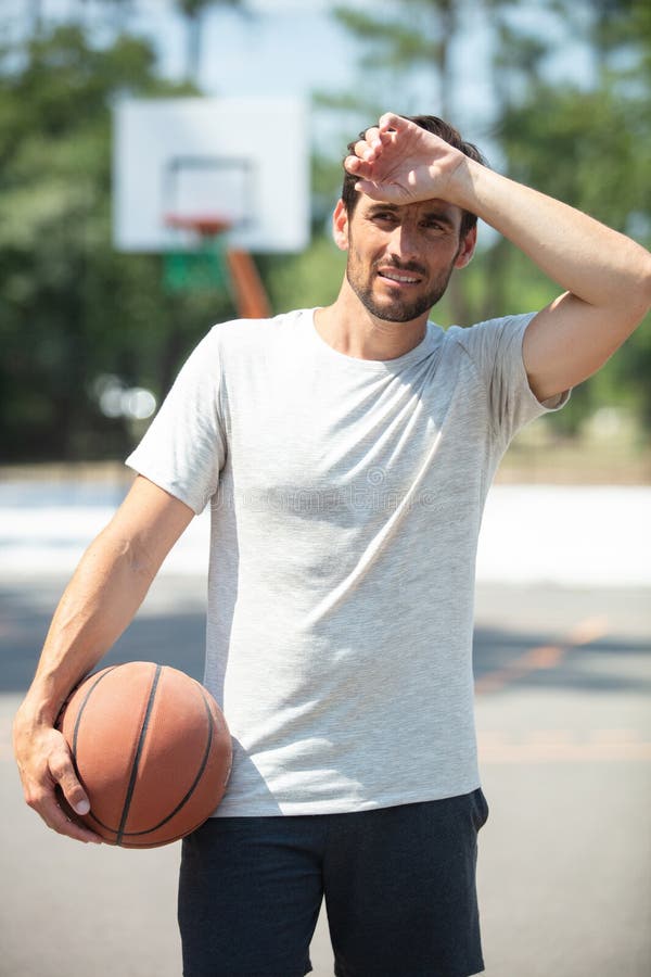 Sweating basketball player in park stock photo
