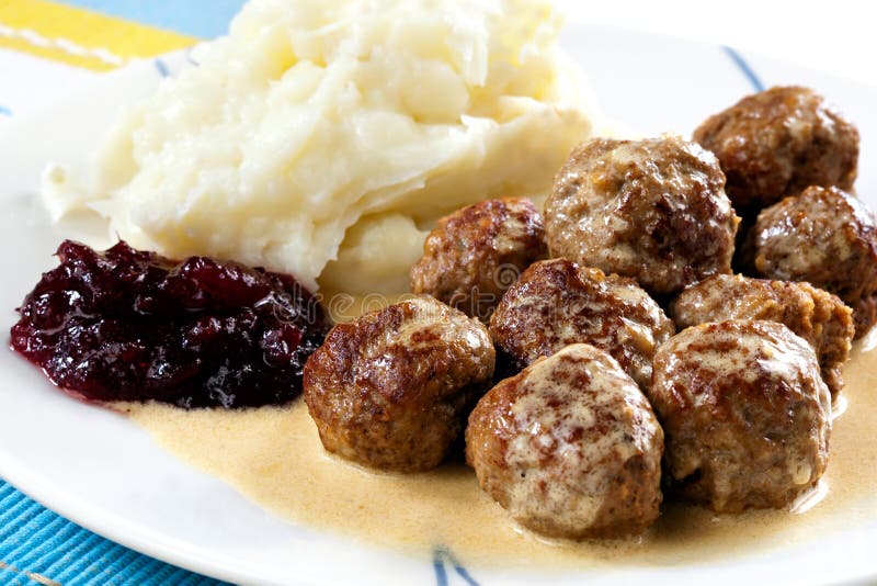 Schwedische Fleischbällchen mit Kartoffelpüree, traditionelle cremige Soße und Preiselbeeren.