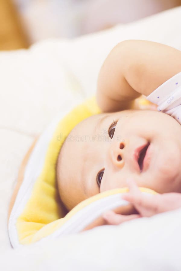 Sweet baby laying on bed stock image. Image of playing 88095049