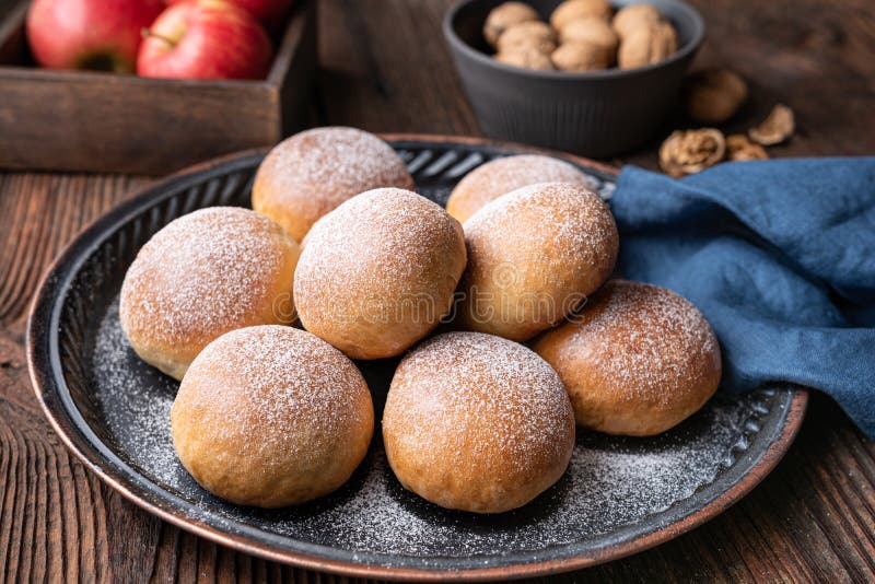 Sweet baked buns with apple and walnut filling, sprinkled with powdered sugar