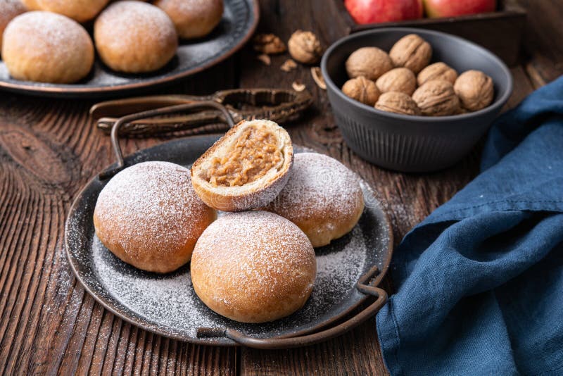 Sweet baked buns with apple and walnut filling, sprinkled with powdered sugar