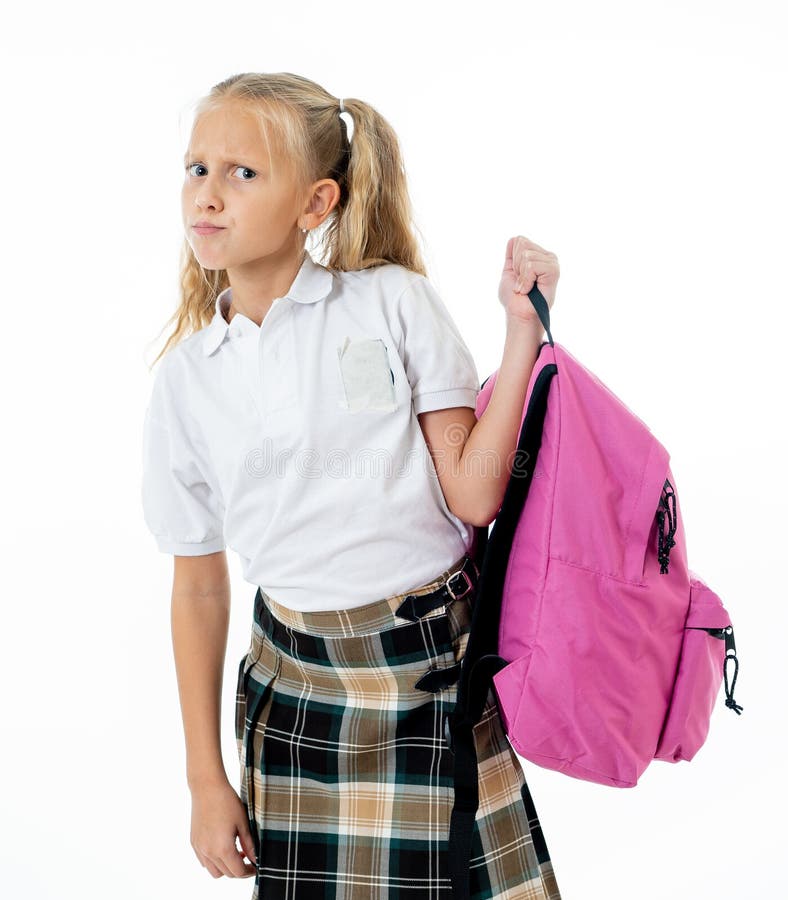Sweet beautiful little girl in school uniform feeling angry and frustrated looking at the camera isolated on white background in royalty free stock photo Sweet beautiful little girl in school uniform feeling angry and frustrated looking at the camera isolated on white background in royalty free stock photo