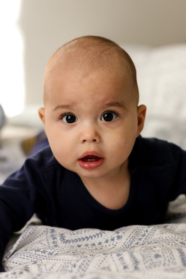 Sweet Chubby Cheeky Baby Boy Lying on His Tummy on the Bed. Funny Face ...