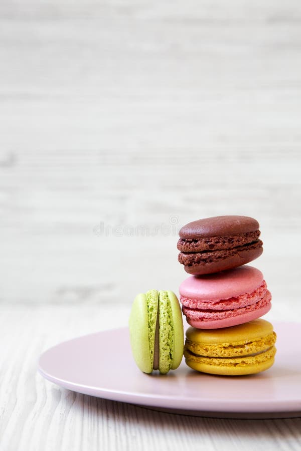 Sweet and Colorful Macarons on Pink Plate Over White Wooden Surface ...