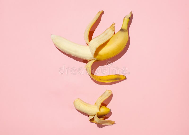 Sweet juicy opened little banana and opened big banana on pink table. Sexual life libido, penis size and potency concept