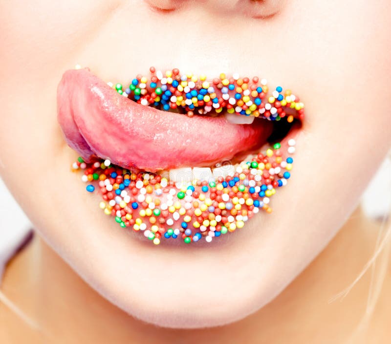 Vista de cerca de una mujer idioma a labios multicolor perlas.