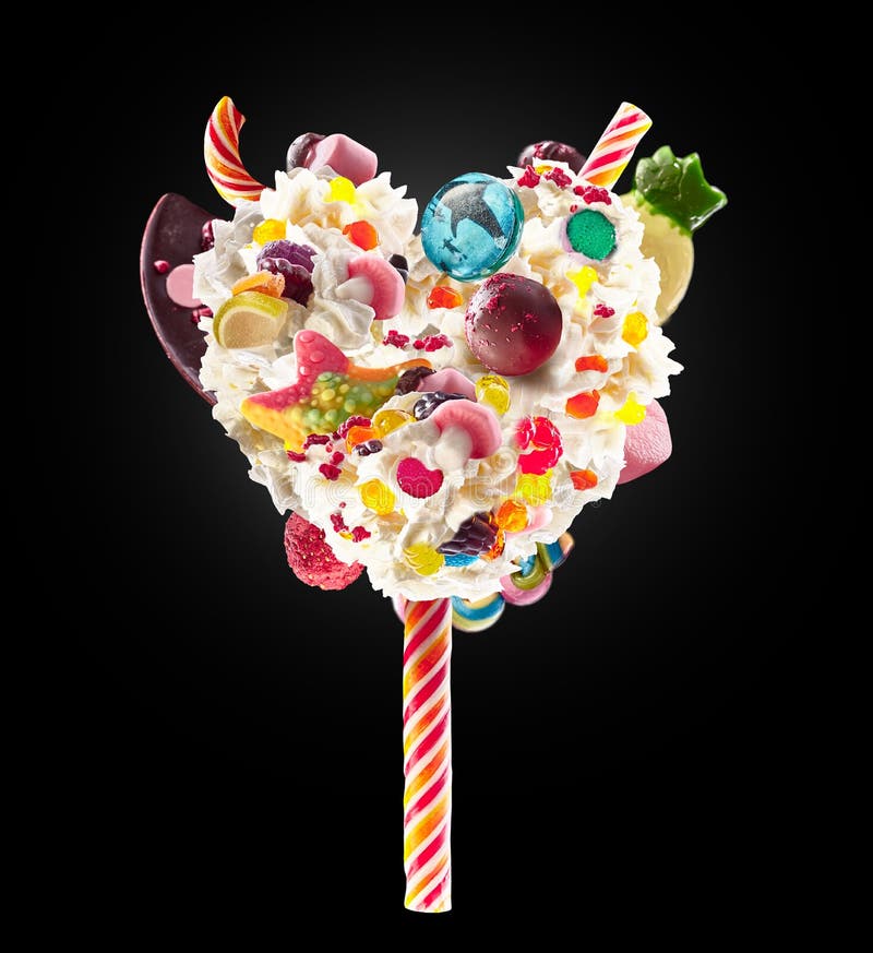 Sweet Lolipop in Heart form of whipped cream with sweets, jellies, heart front view. Crazy freakshake food trend. Front stock photo Sweet Lolipop in Heart form of whipped cream with sweets, jellies, heart front view. Crazy freakshake food trend. Front stock photo