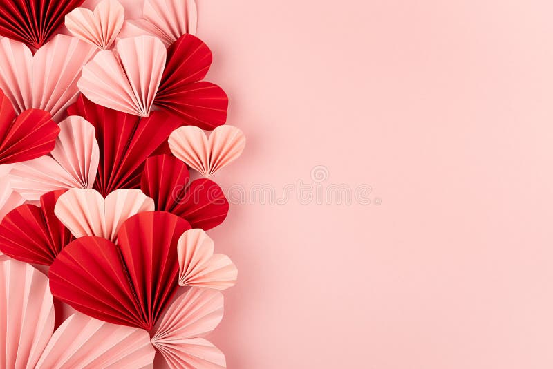 Sweet love background for wedding or Valentine day with heap many gentle pink and red paper hearts on pink backdrop, sideways.