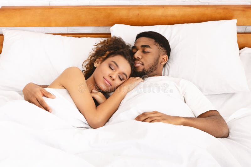 Couple sleeping romantically in a double bed